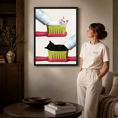 toothpaste kitten duo canvas art shown in the black frame option against a softly lit wall.