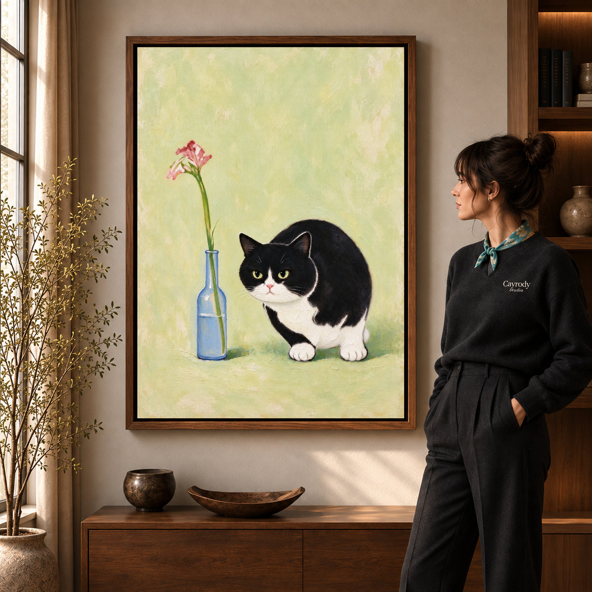 cat flower companion canvas art in a walnut frame beside a standing woman and wooden console.