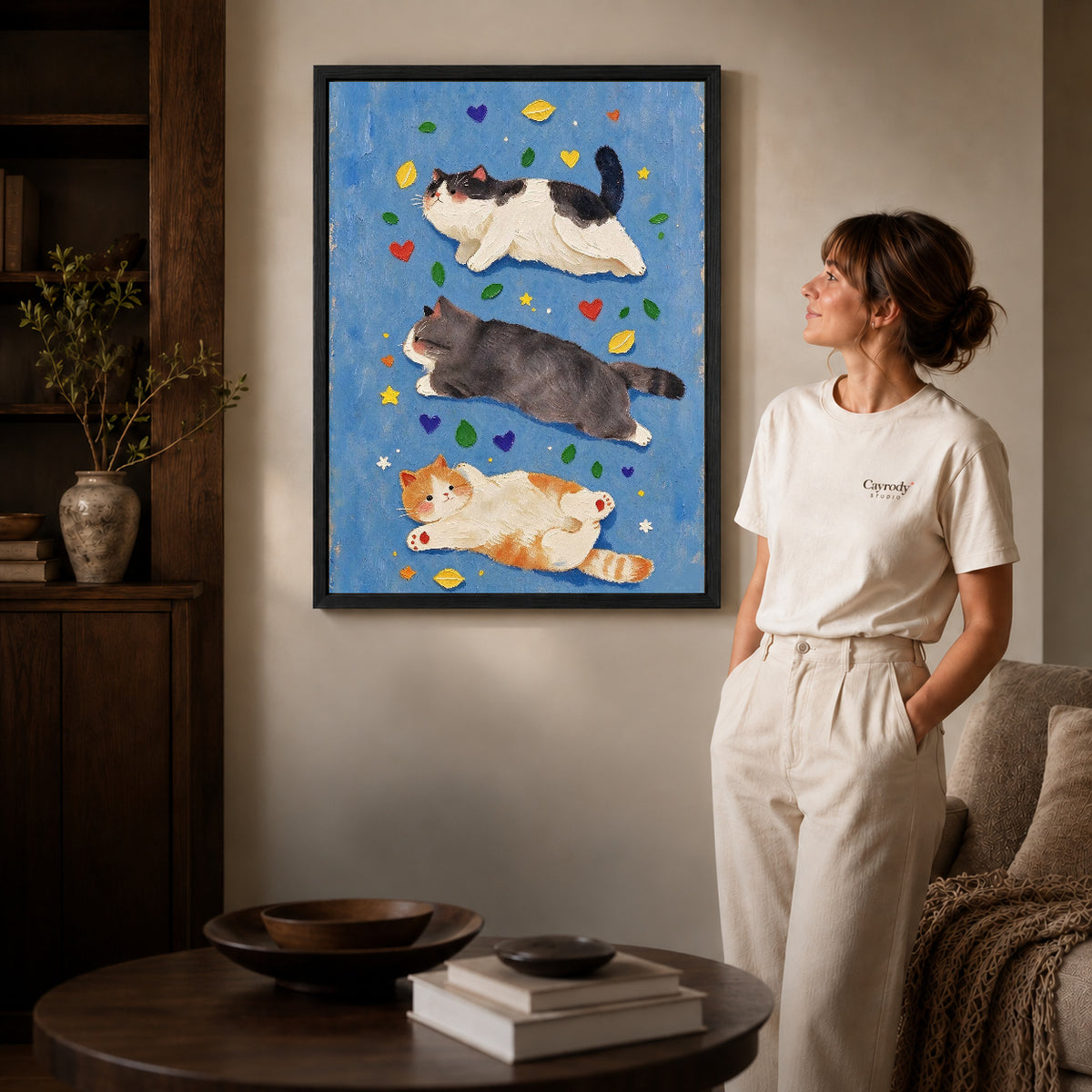 three resting cats canvas art shown in the black frame option against a softly lit wall.
