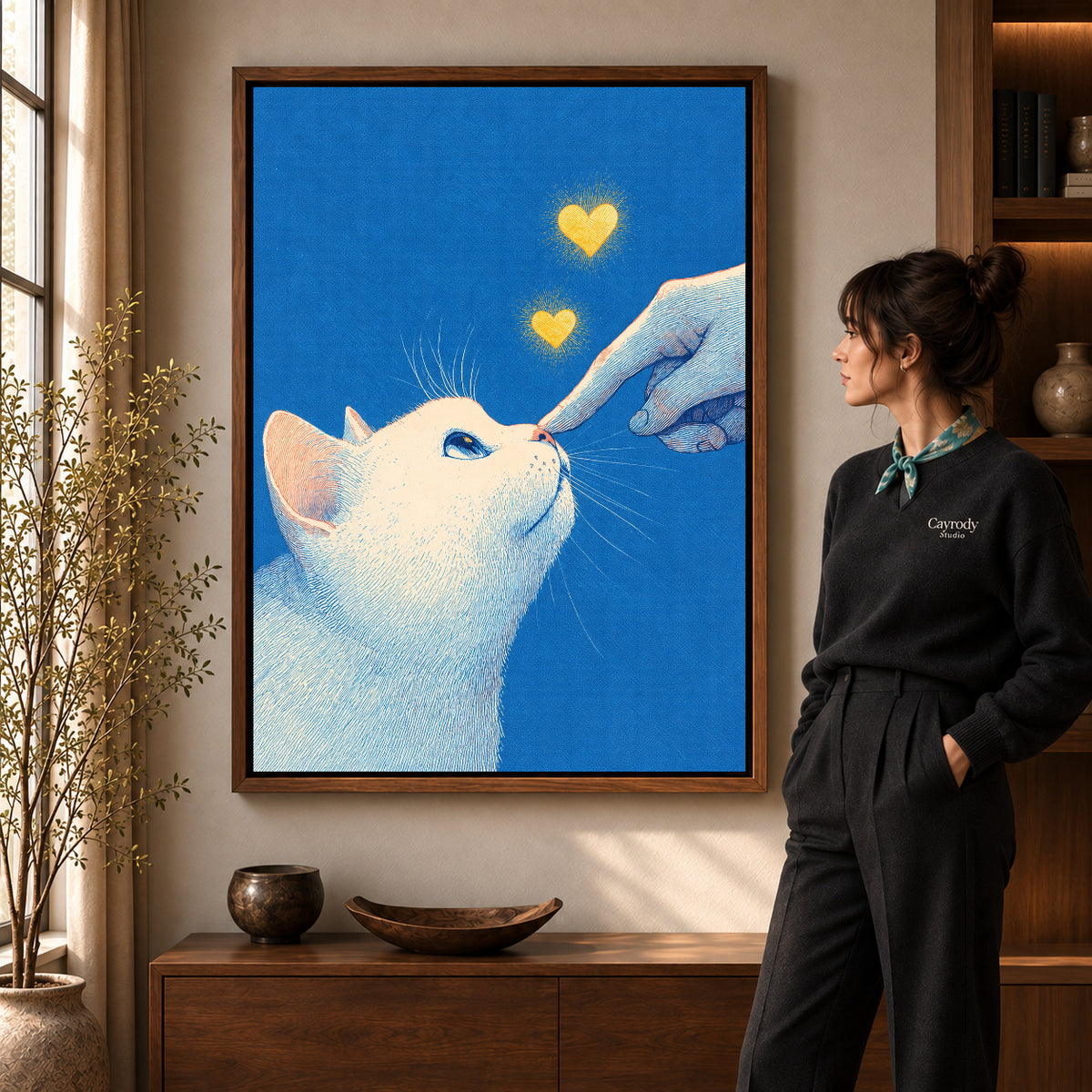 gentle cat greeting canvas art in a walnut frame beside a standing woman and wooden console.