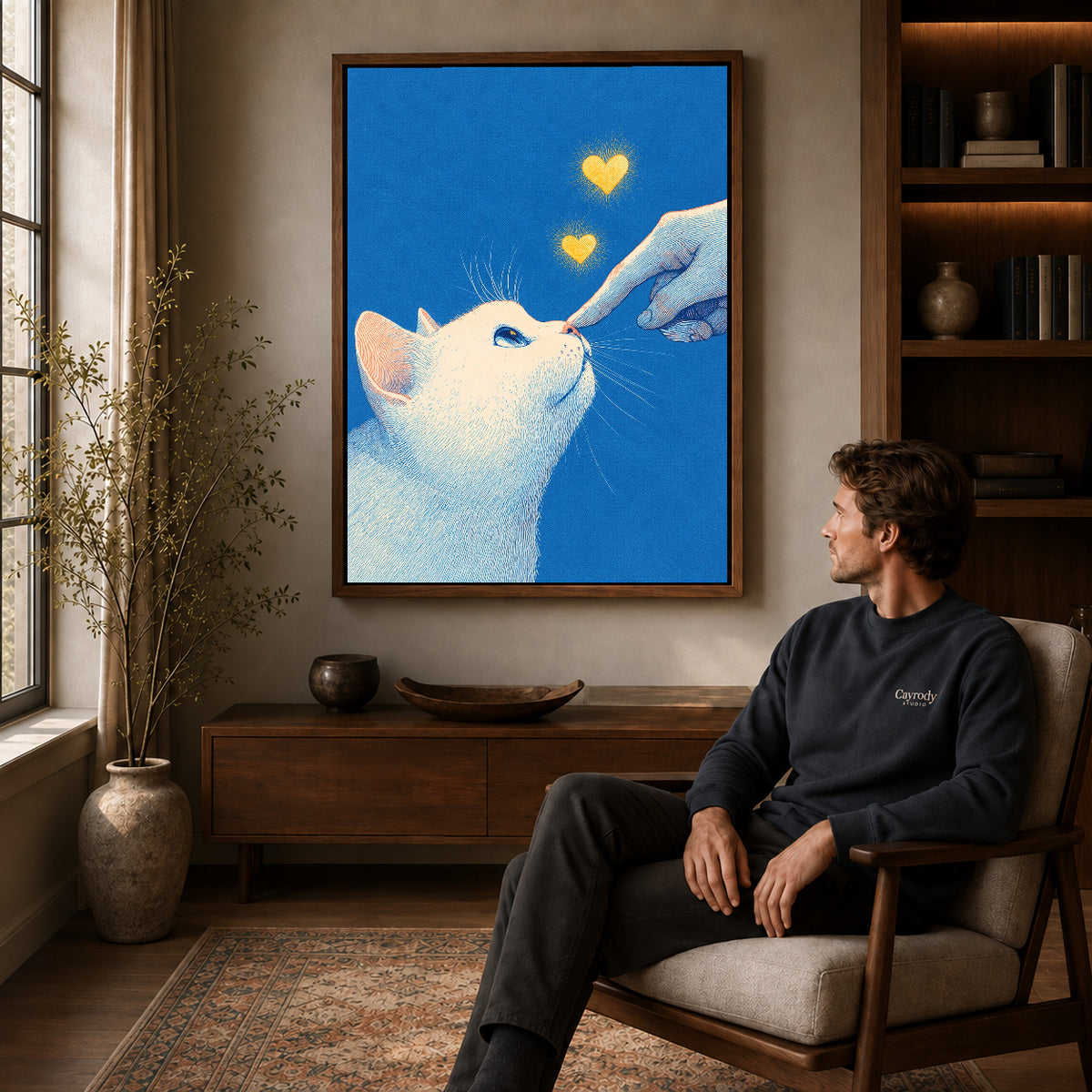 gentle cat greeting canvas art in a walnut frame above a console beside a seated man.