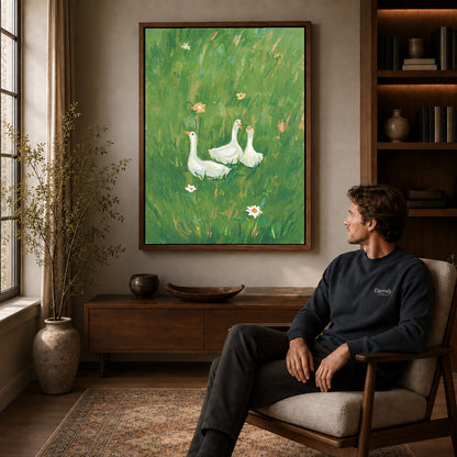 meadow goose trio canvas art in a walnut frame above a console beside a seated man.