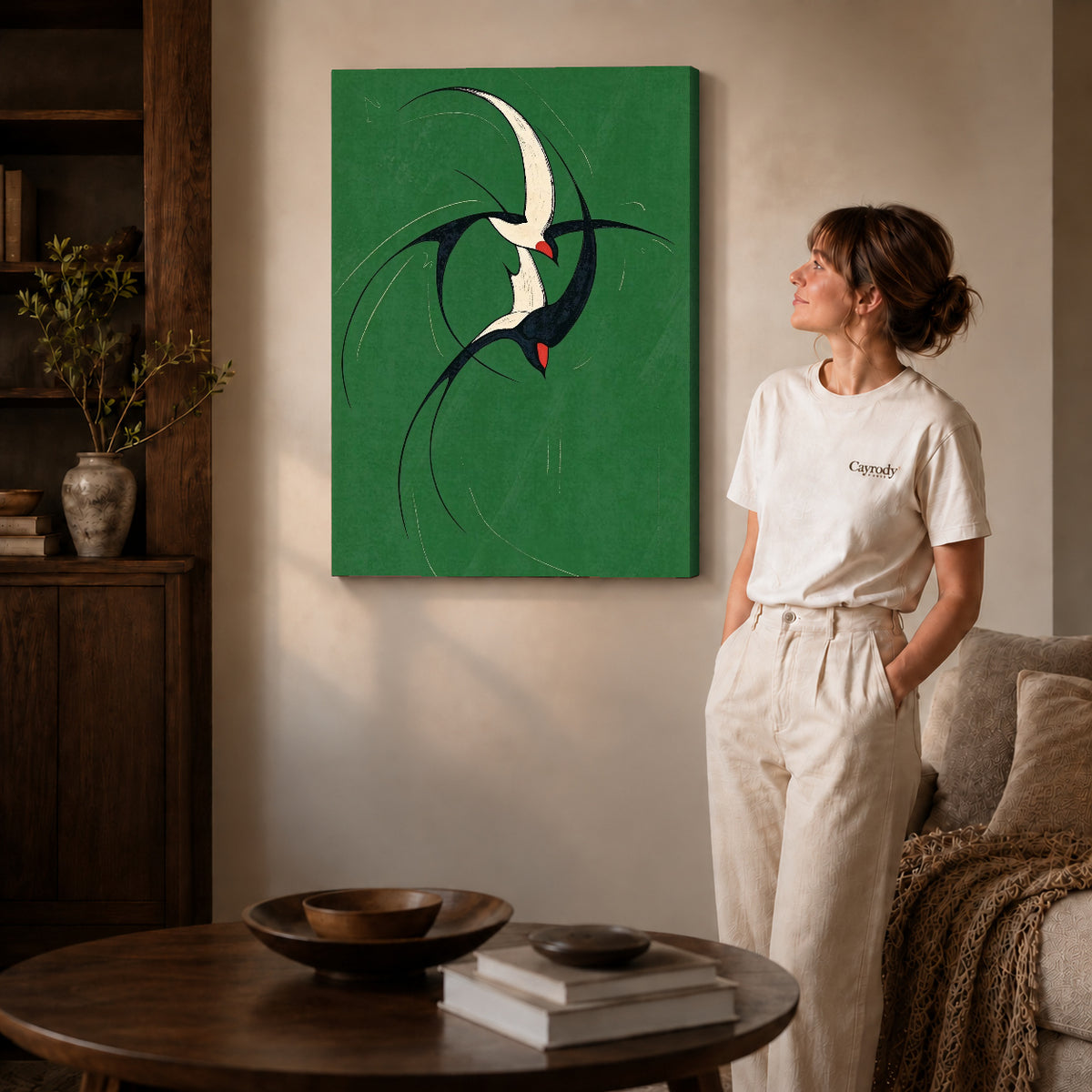 graceful swallow pair canvas art on gallery-wrapped canvas with natural edge shading beside a standing woman.