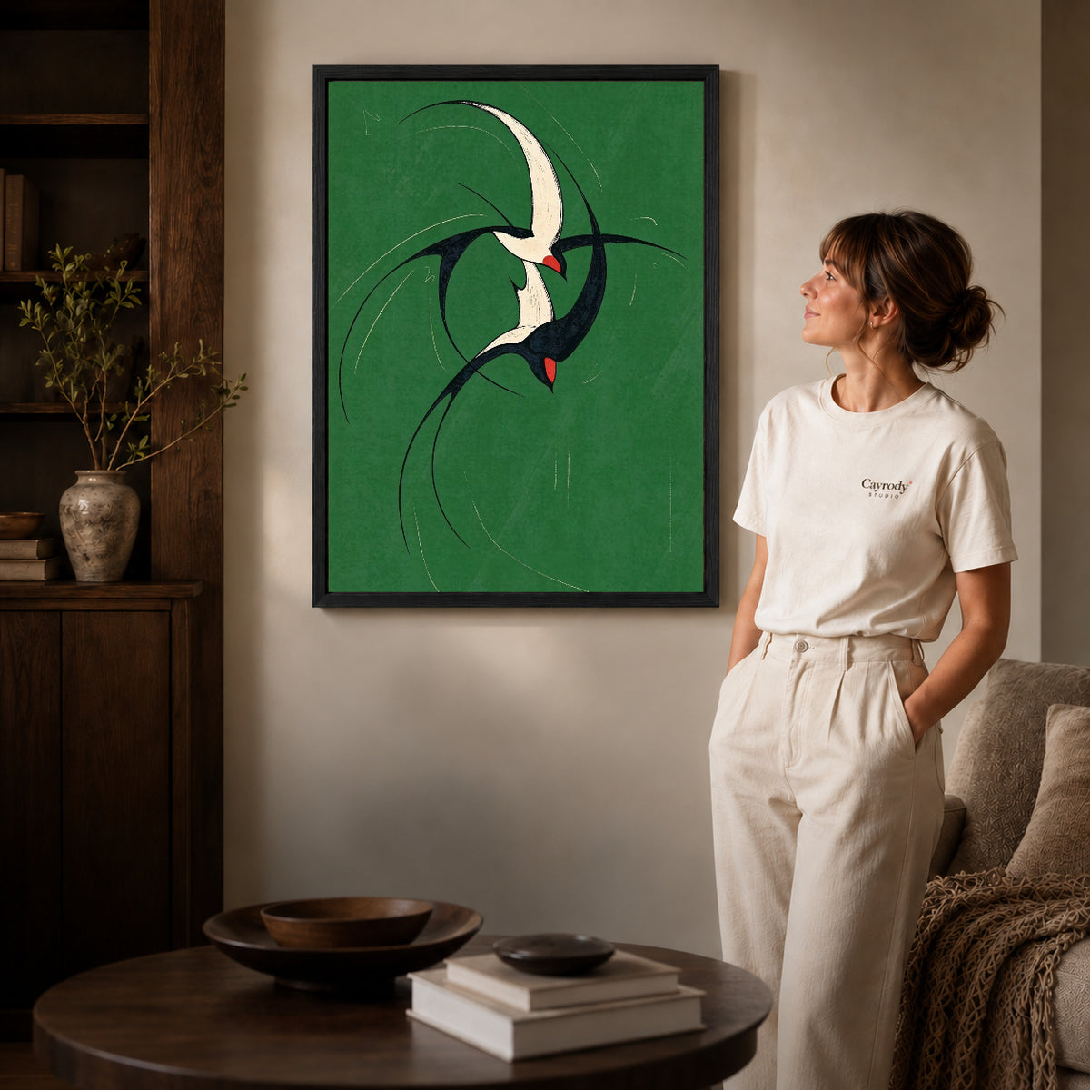 graceful swallow pair canvas art shown in the black frame option against a softly lit wall.