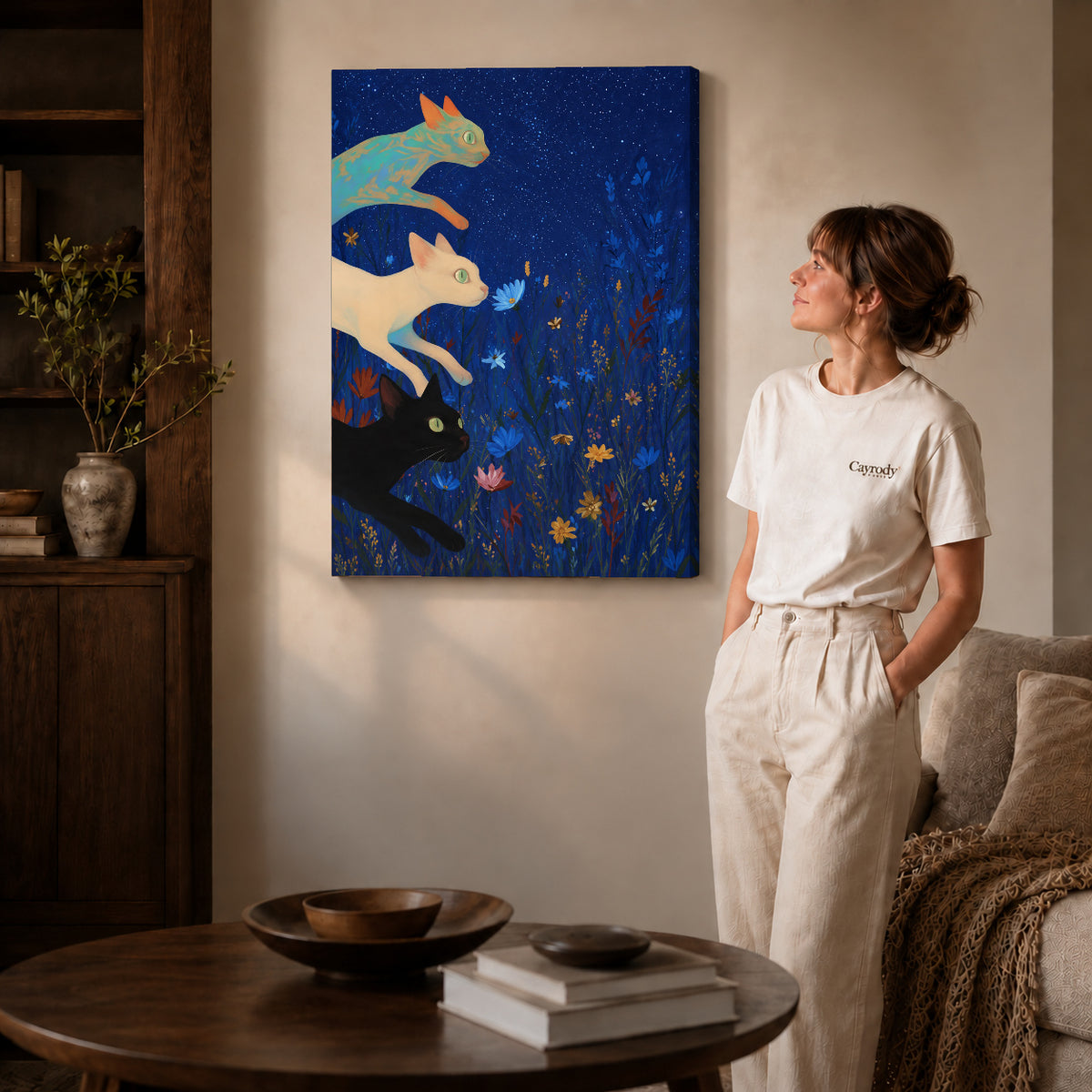 starry meadow cats canvas art on gallery-wrapped canvas with natural edge shading beside a standing woman.