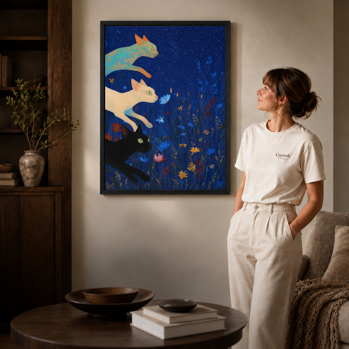 starry meadow cats canvas art shown in the black frame option against a softly lit wall.