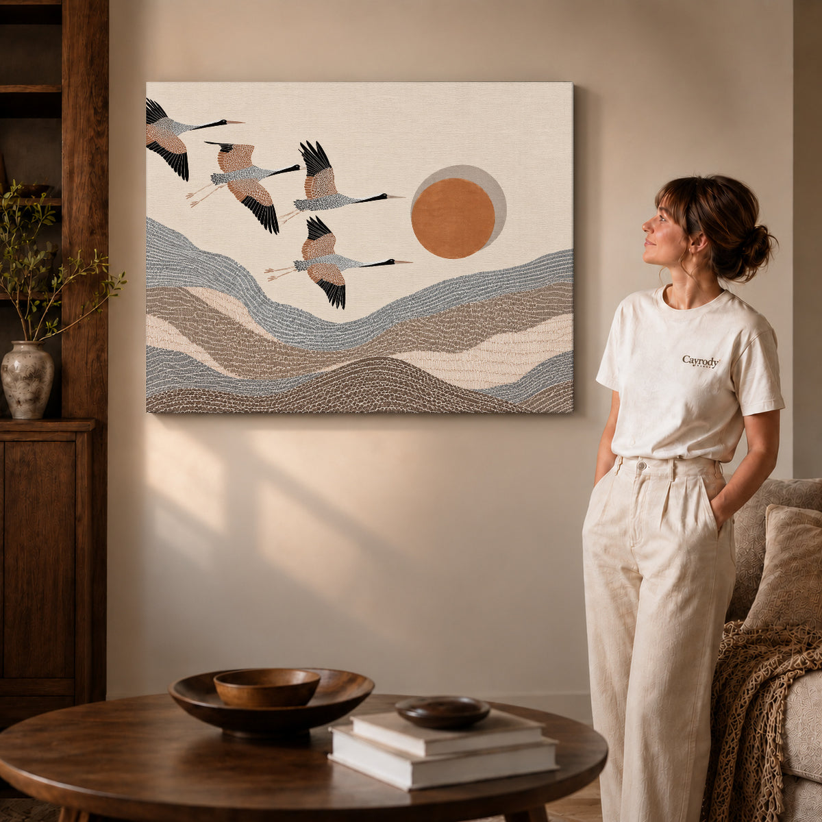cranes mountain flight canvas art on gallery-wrapped canvas with visible edge depth beside a standing woman.