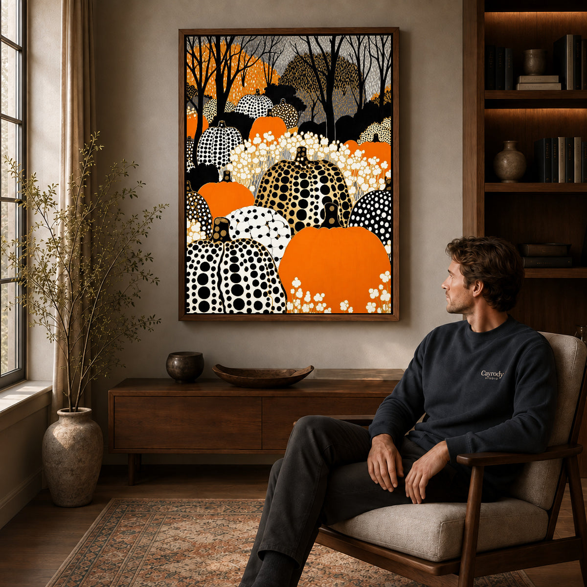 patterned pumpkin woods canvas art in a walnut frame above a console beside a seated man.
