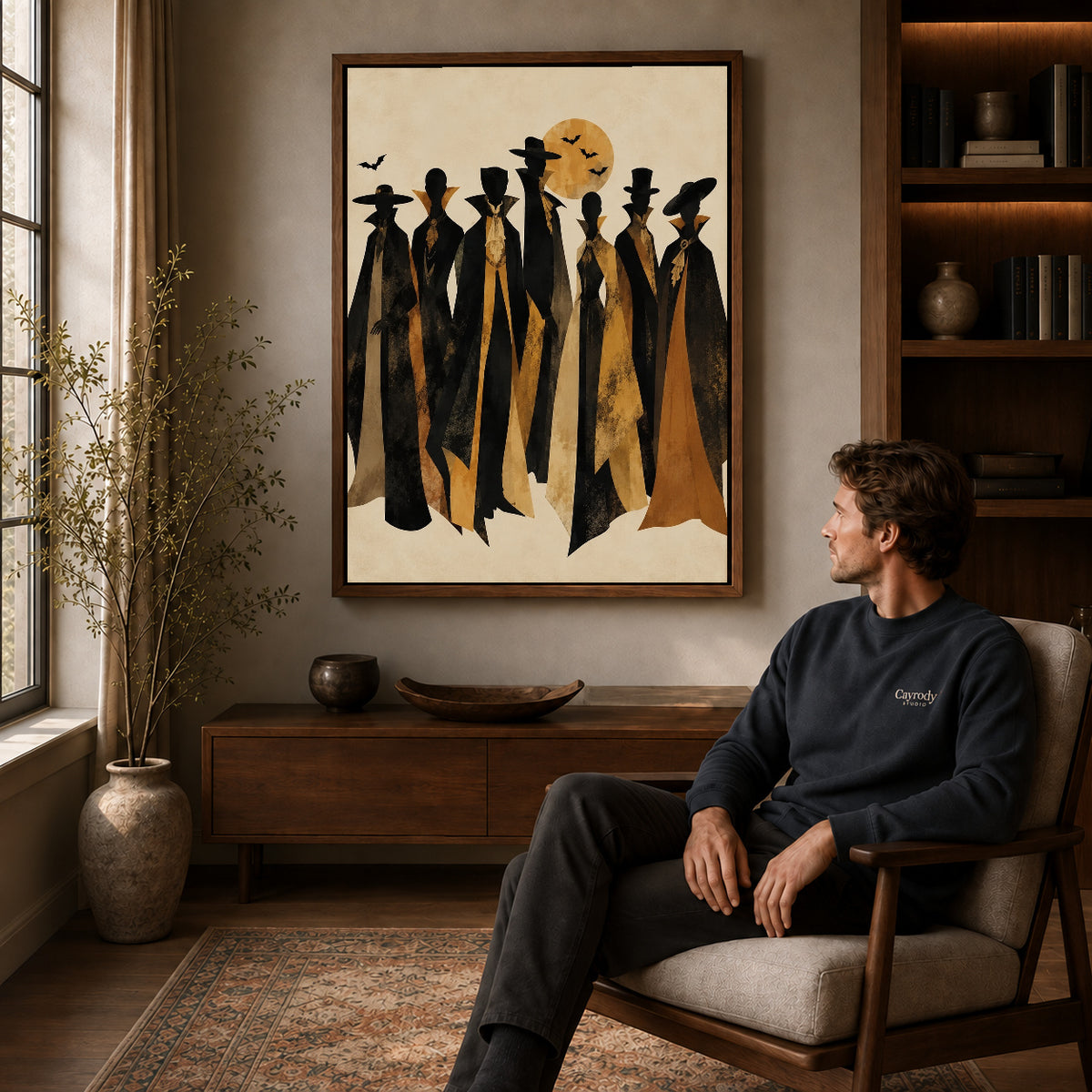 autumn cloaked gathering canvas art in a walnut frame above a console beside a seated man.