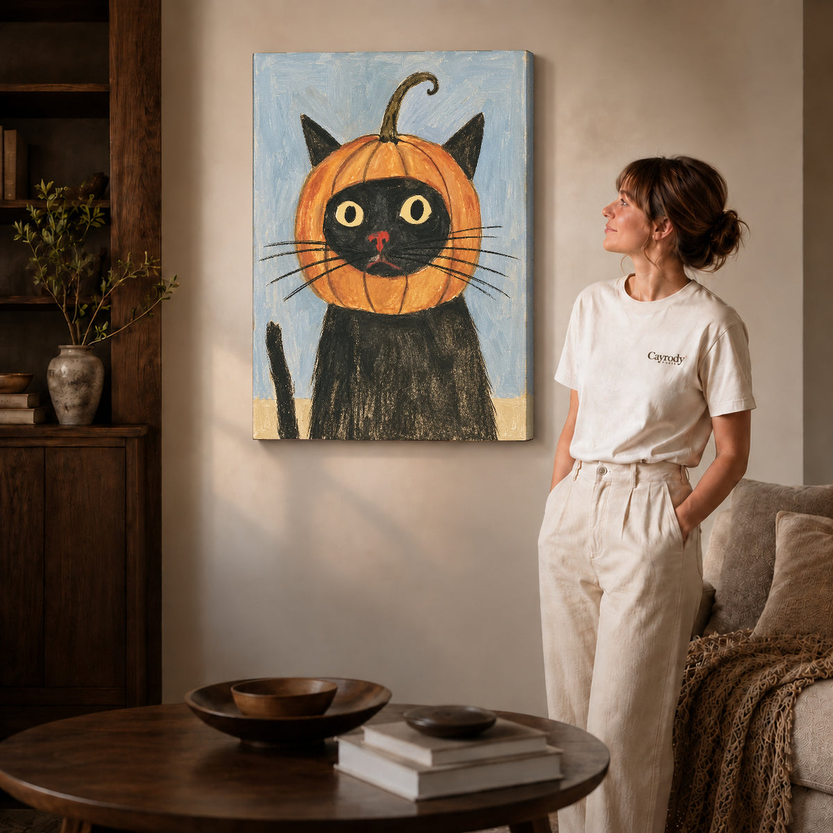 pumpkin hood cat canvas art on gallery-wrapped canvas with natural edge shading beside a standing woman.