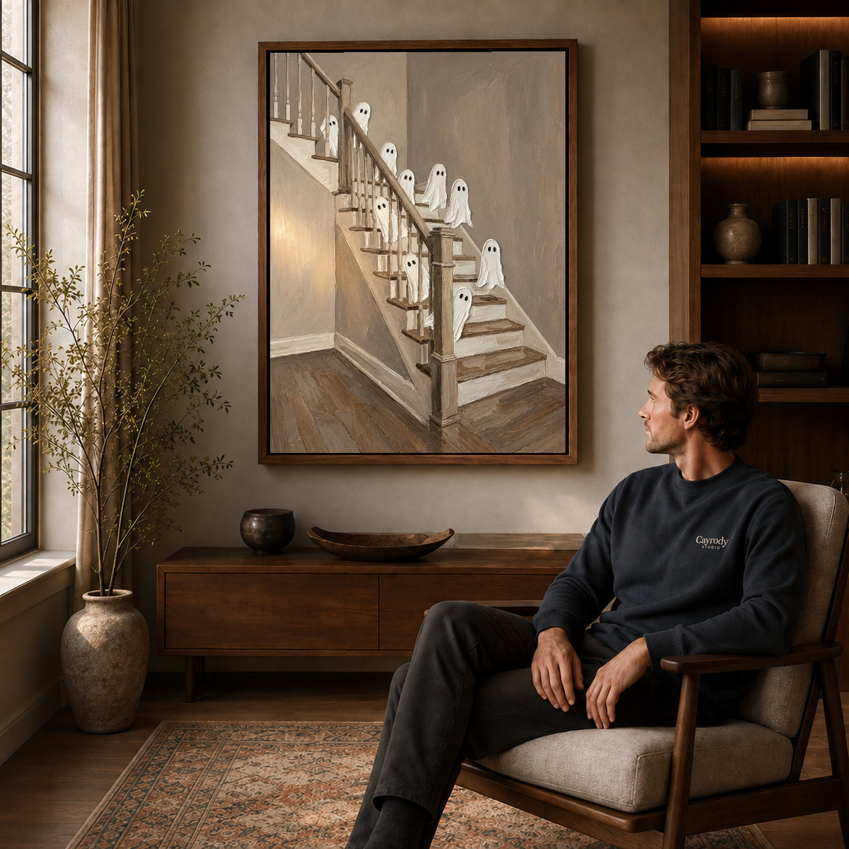 staircase ghost gathering canvas art in a walnut frame above a console beside a seated man.