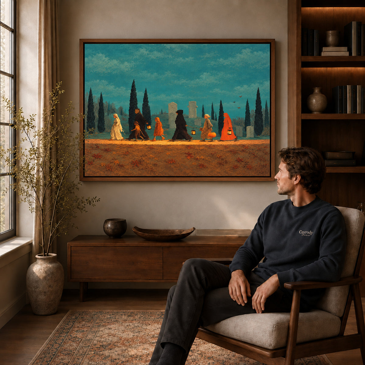autumn lantern procession canvas art in a walnut frame above a console beside a seated man.