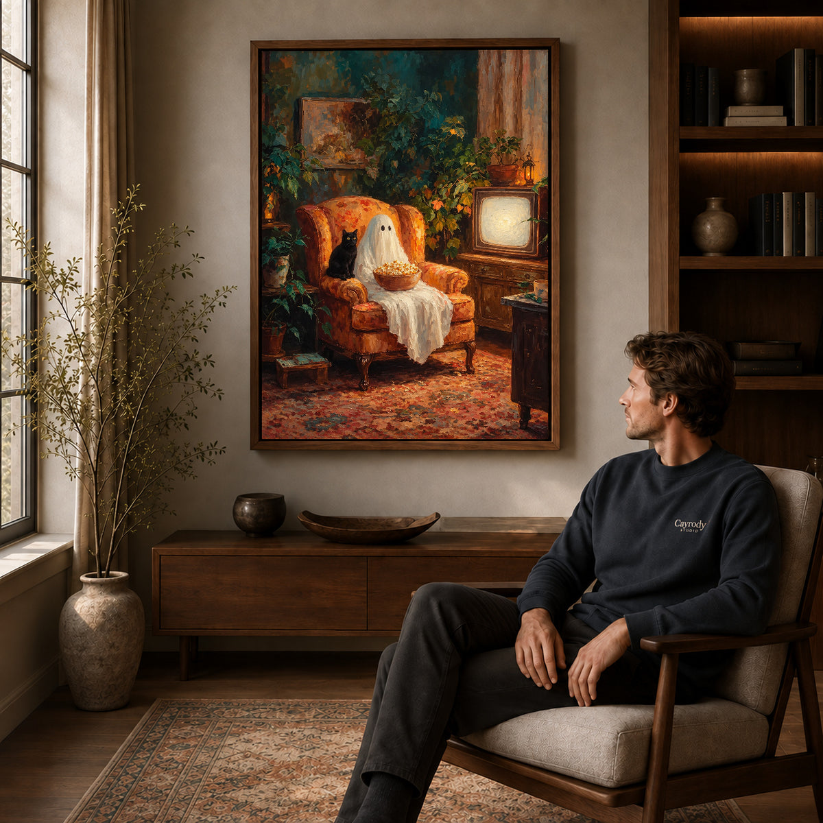 popcorn ghost evening canvas art in a walnut frame above a console beside a seated man.