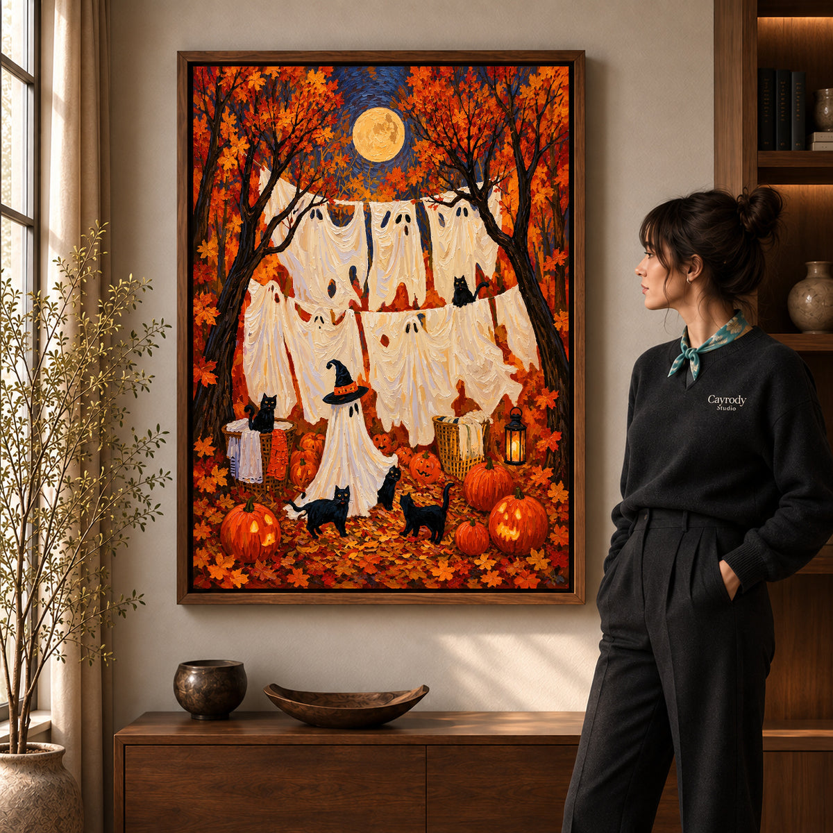 autumn ghost laundry canvas art in a walnut frame beside a standing woman and wooden console.