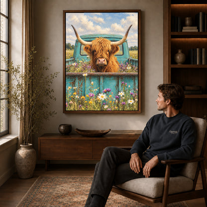 highland cow pickup canvas art in a walnut frame above a console beside a seated man.