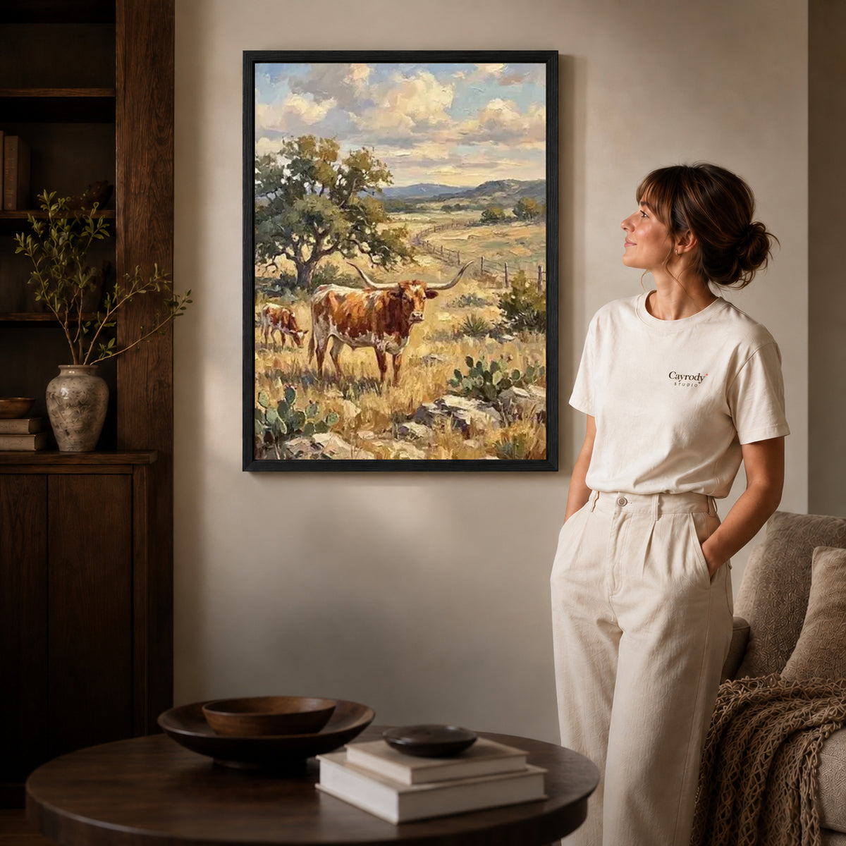 golden longhorn pasture canvas art shown in the black frame option against a softly lit wall.