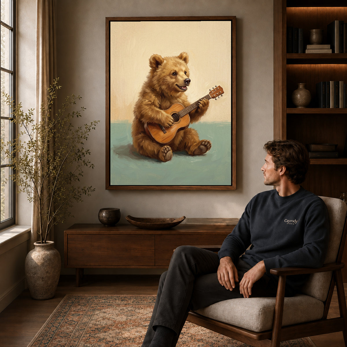 happy guitar bear canvas art in a walnut frame above a console beside a seated man.