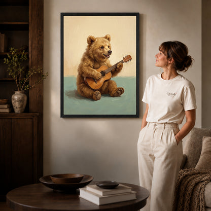 happy guitar bear canvas art in a black frame beside a woman and round wooden table.