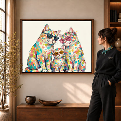 colorful cat family canvas art in a walnut frame beside a standing woman and wooden console.