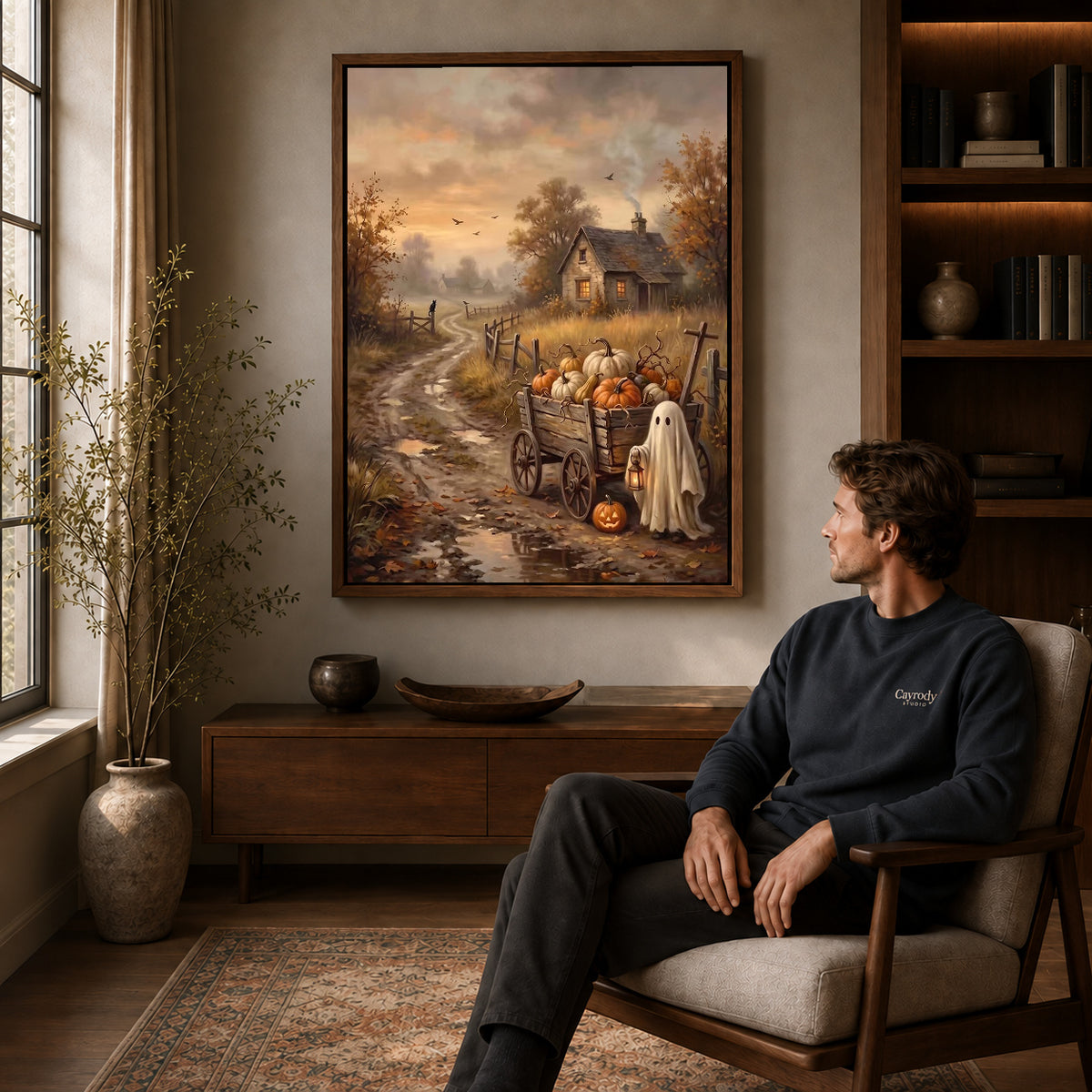 lantern ghost wagon canvas art in a walnut frame above a console beside a seated man.