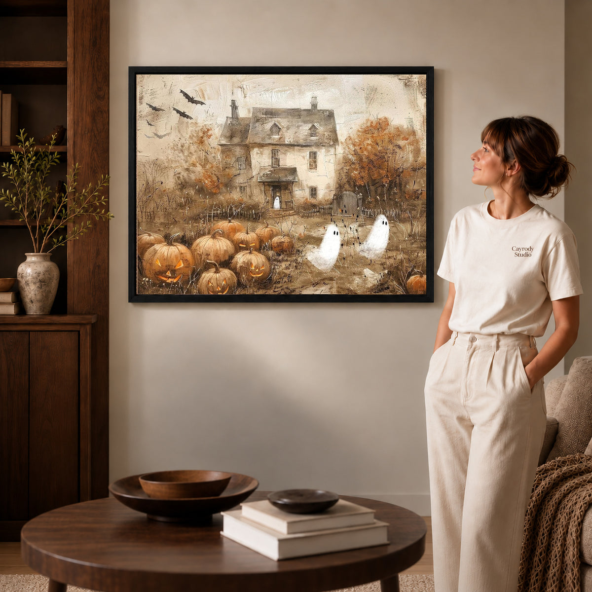 vintage ghost cottage canvas art shown in the black frame option against a softly lit wall.