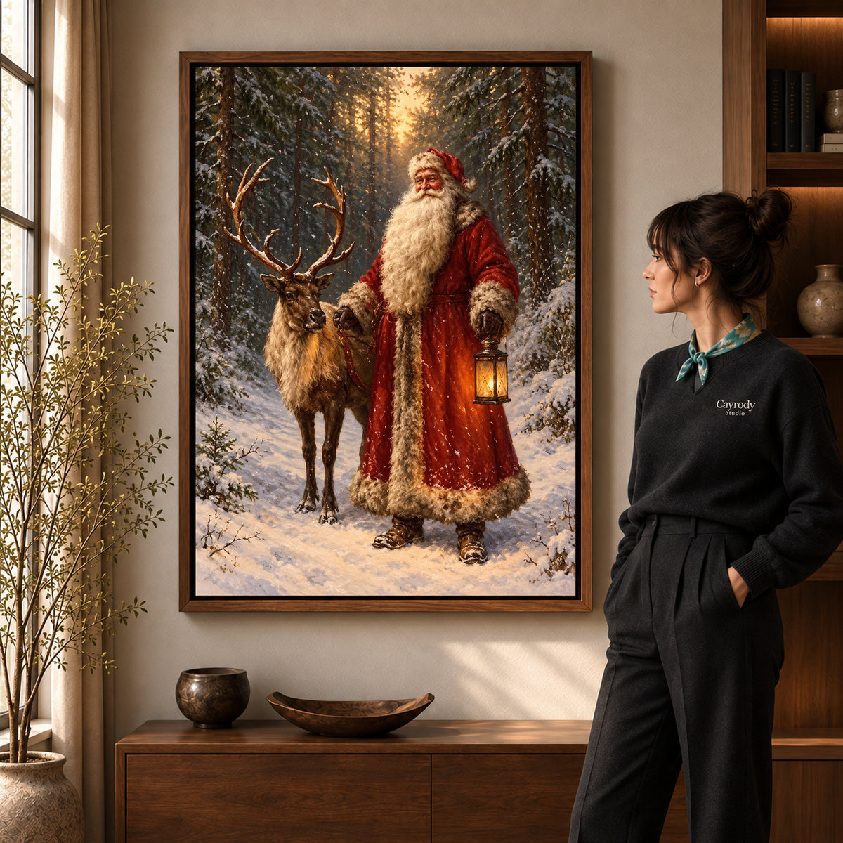 winter lantern santa canvas art in a walnut frame beside a standing woman and wooden console.