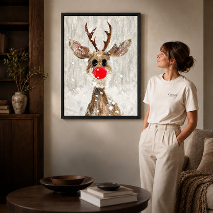 snowy red nose deer canvas art shown in the black frame option against a softly lit wall.