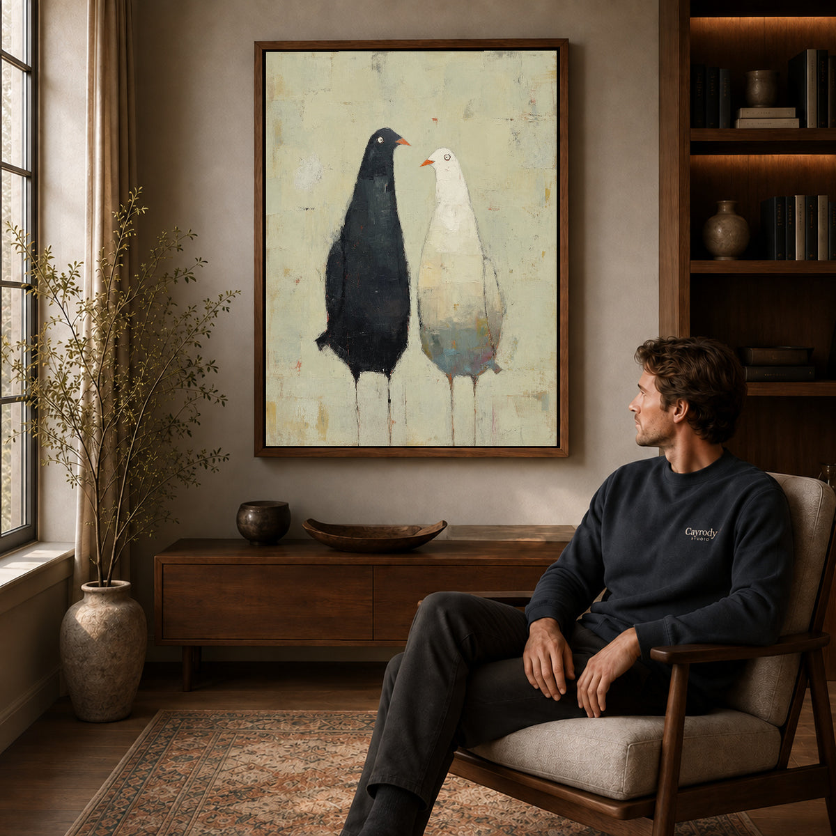 quiet bird companions canvas art in a walnut frame above a console beside a seated man.