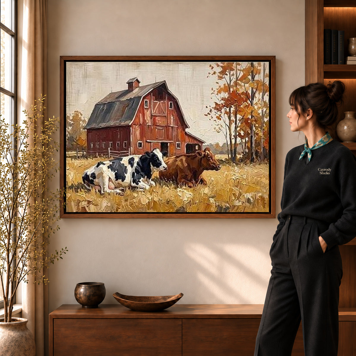 red barn companions canvas art in a walnut frame beside a standing woman and wooden console.