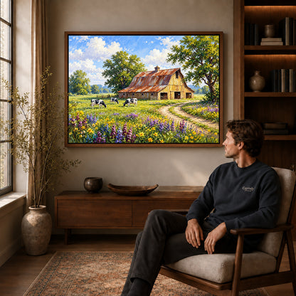 sunlit country barn canvas art in a walnut frame above a console beside a seated man.