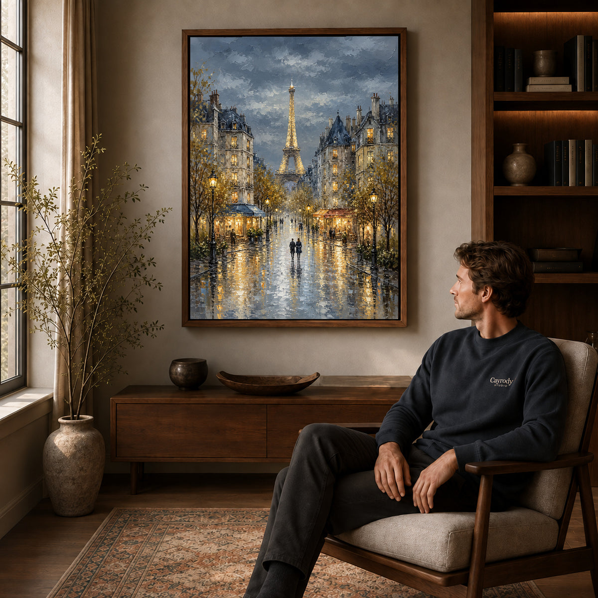 rainy paris evening canvas art in a walnut frame above a console beside a seated man.