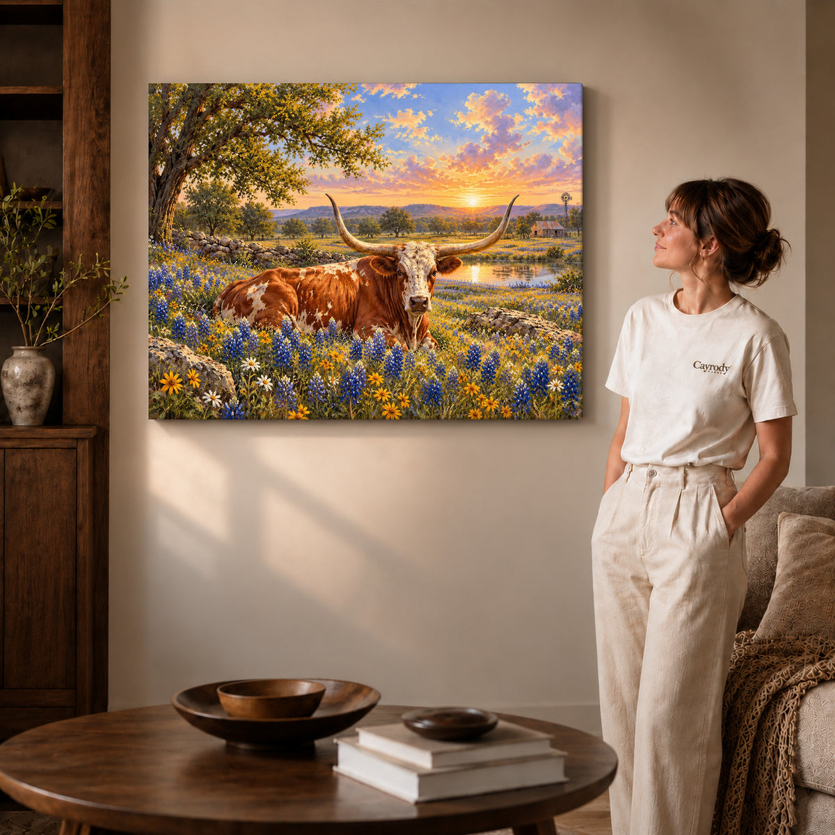 sunset longhorn meadow canvas art on gallery-wrapped canvas with visible edge depth beside a standing woman.