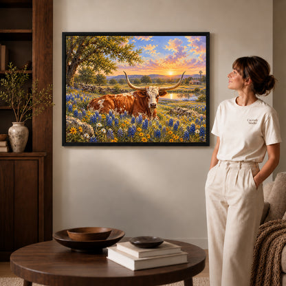 sunset longhorn meadow canvas art shown in the black frame option against a softly lit wall.