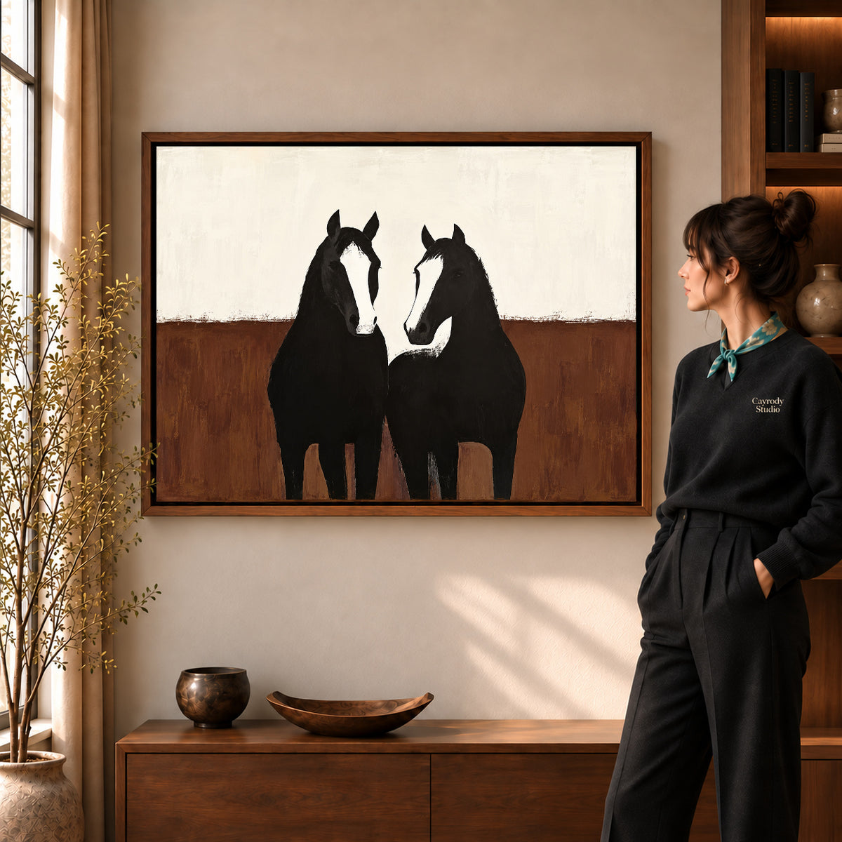 quiet horse companions canvas art in a walnut frame beside a standing woman and wooden console.