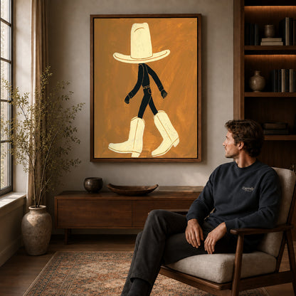 oversized cowboy boots canvas art in a walnut frame above a console beside a seated man.