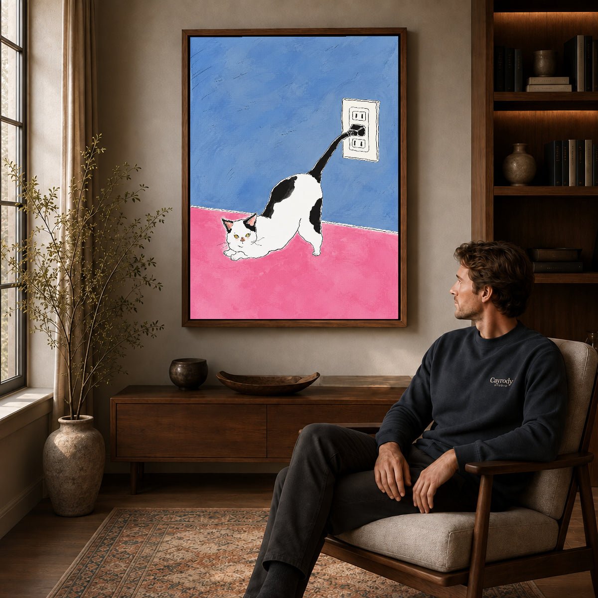 plug tail cat canvas art in a walnut frame above a console beside a seated man.