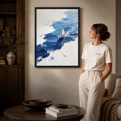 blue impasto sailboat canvas art shown in the black frame option against a softly lit wall.