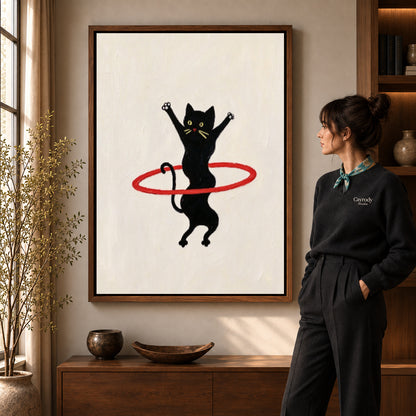 hula hoop cat canvas art in a walnut frame beside a standing woman and wooden console.