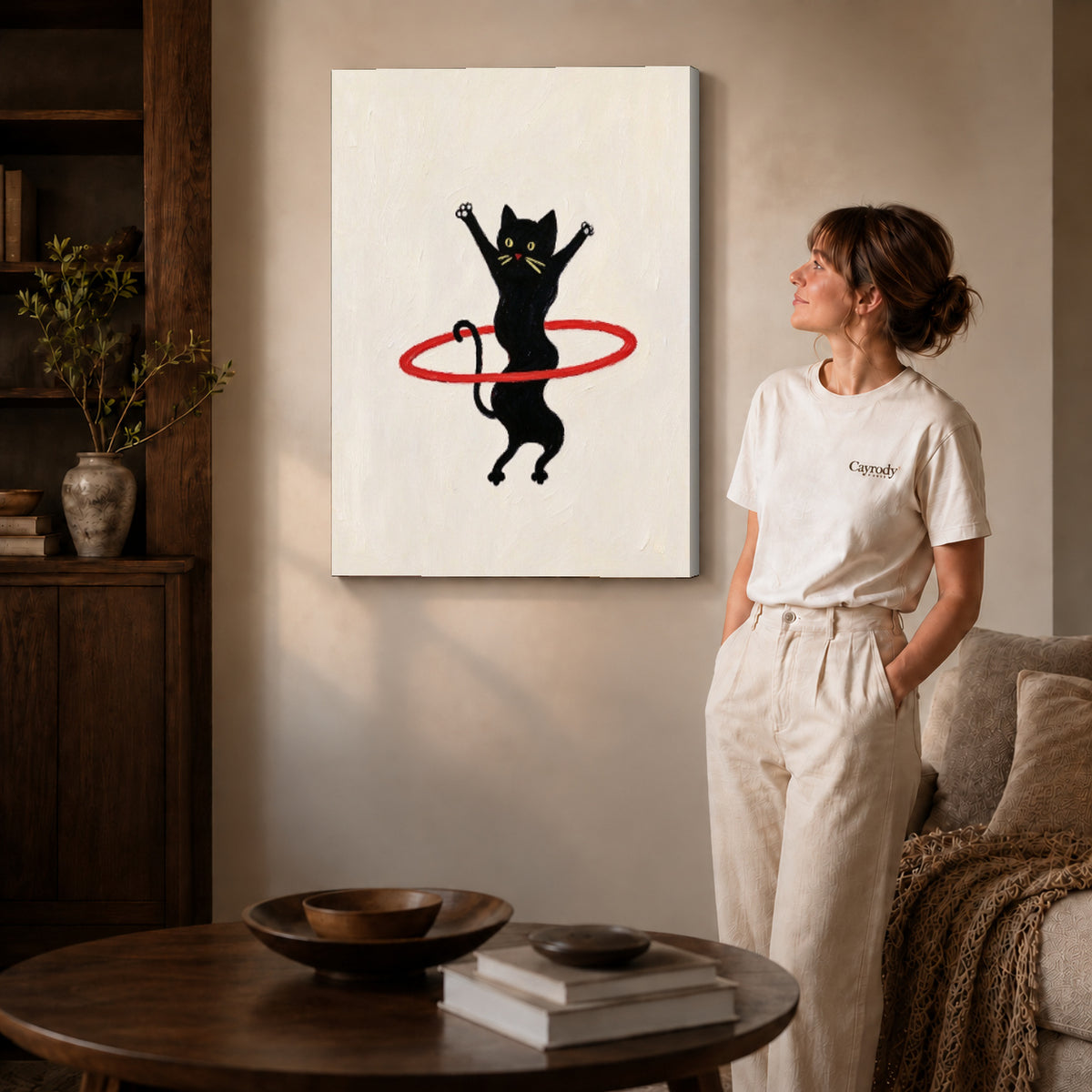 hula hoop cat canvas art on gallery-wrapped canvas with natural edge shading beside a standing woman.