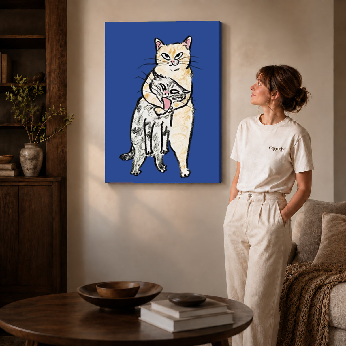 curious cat companions canvas art on gallery-wrapped canvas with natural edge shading beside a standing woman.