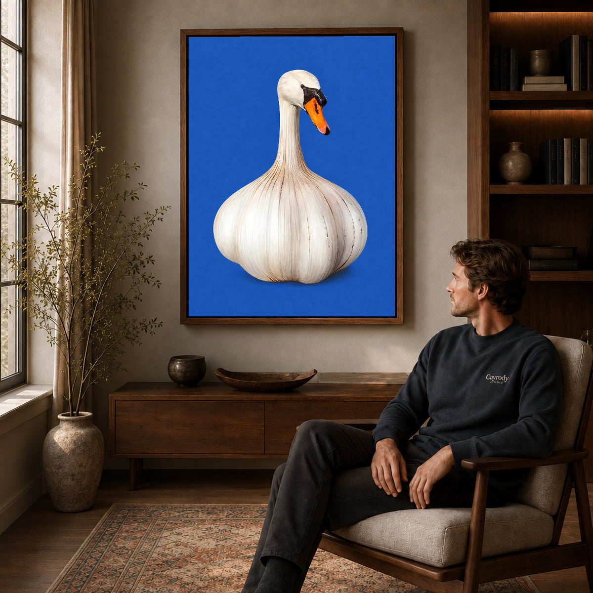 whimsical garlic swan canvas art in a walnut frame above a console beside a seated man.