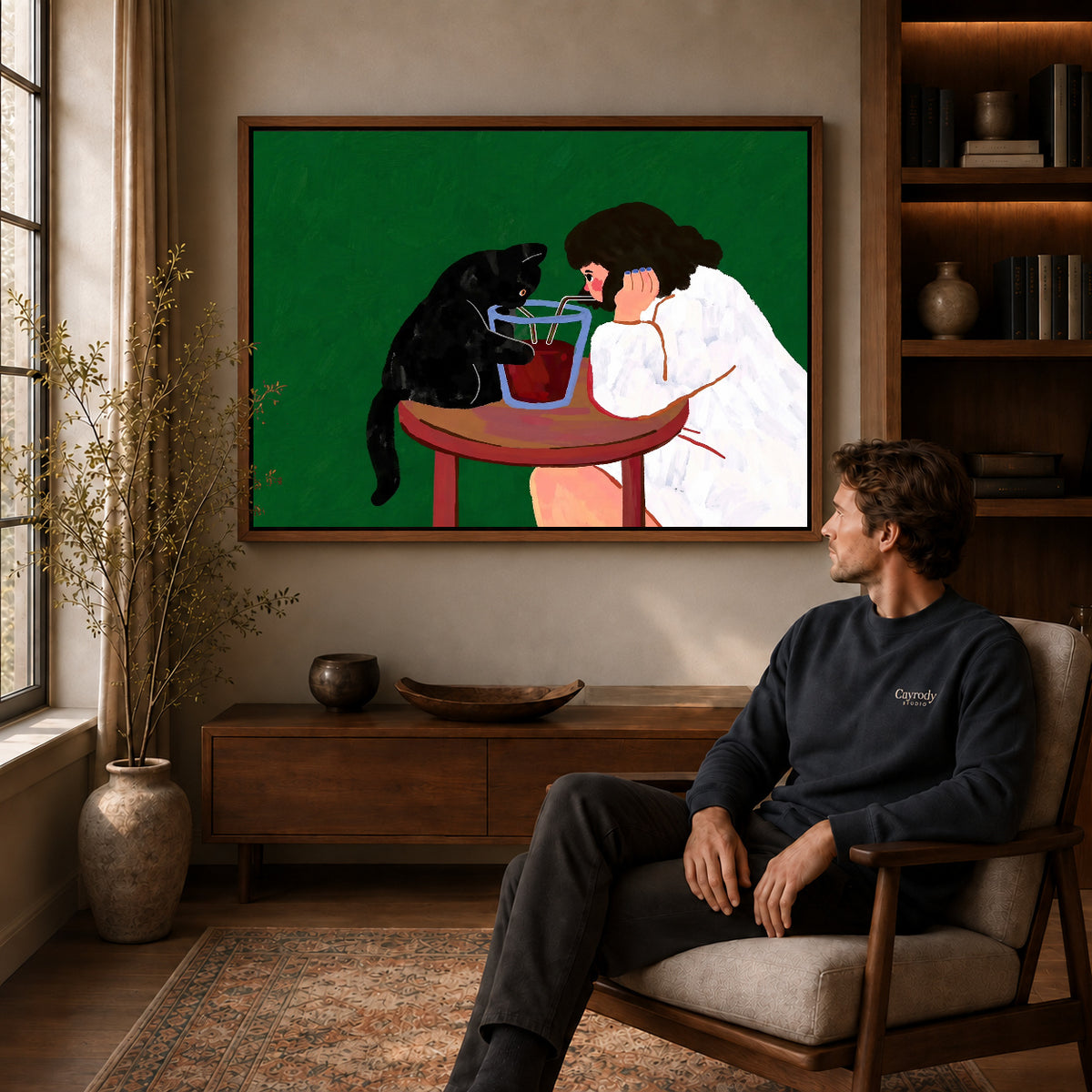 shared sip companions canvas art in a walnut frame above a console beside a seated man.