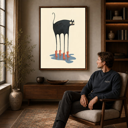 red boots cat canvas art in a walnut frame above a console beside a seated man.