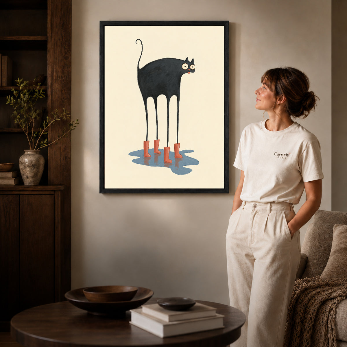red boots cat canvas art shown in the black frame option against a softly lit wall.