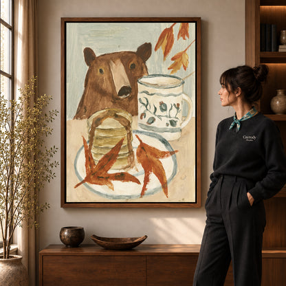 breakfast bear companion canvas art in a walnut frame beside a standing woman and wooden console.