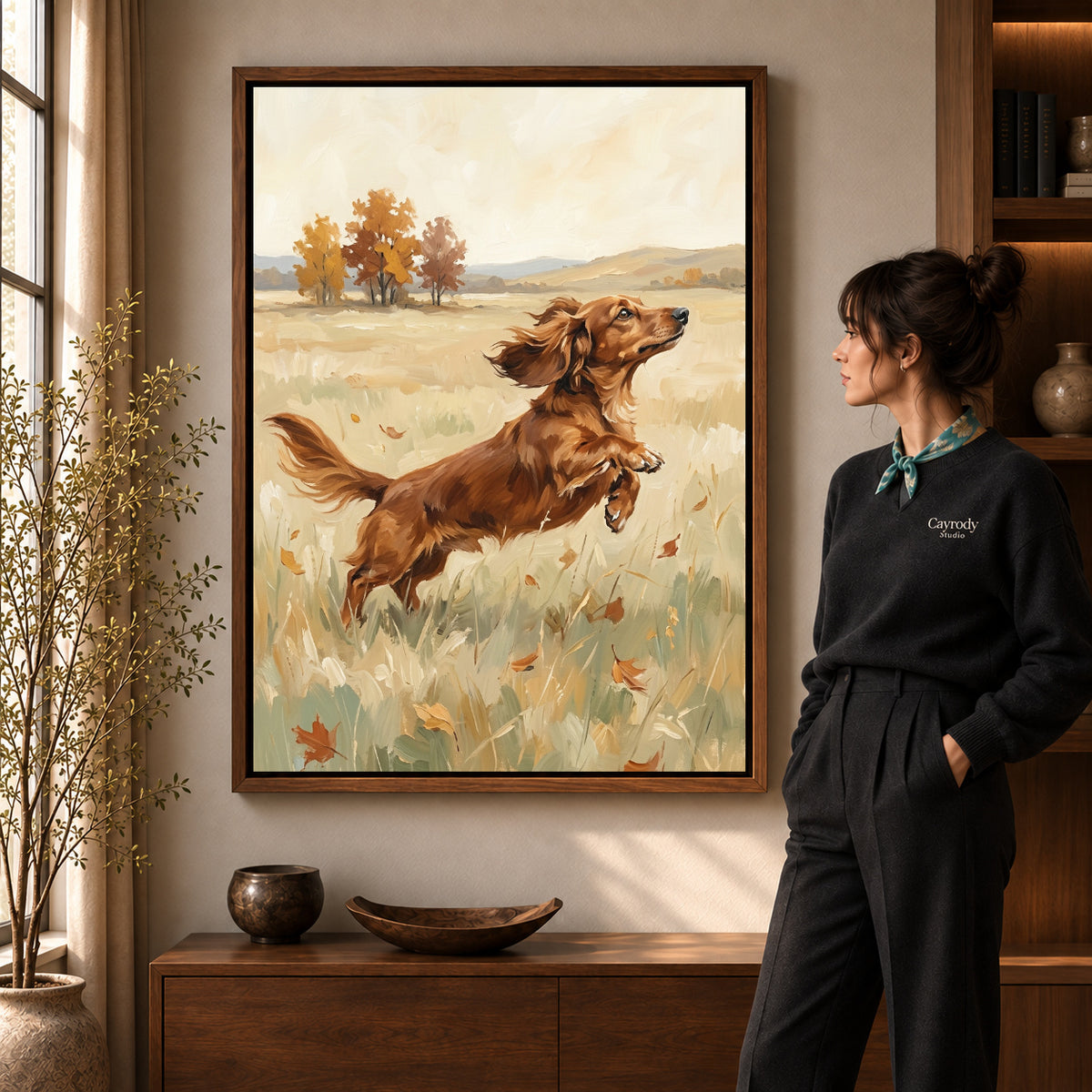 playful dachshund leap canvas art in a walnut frame beside a standing woman and wooden console.