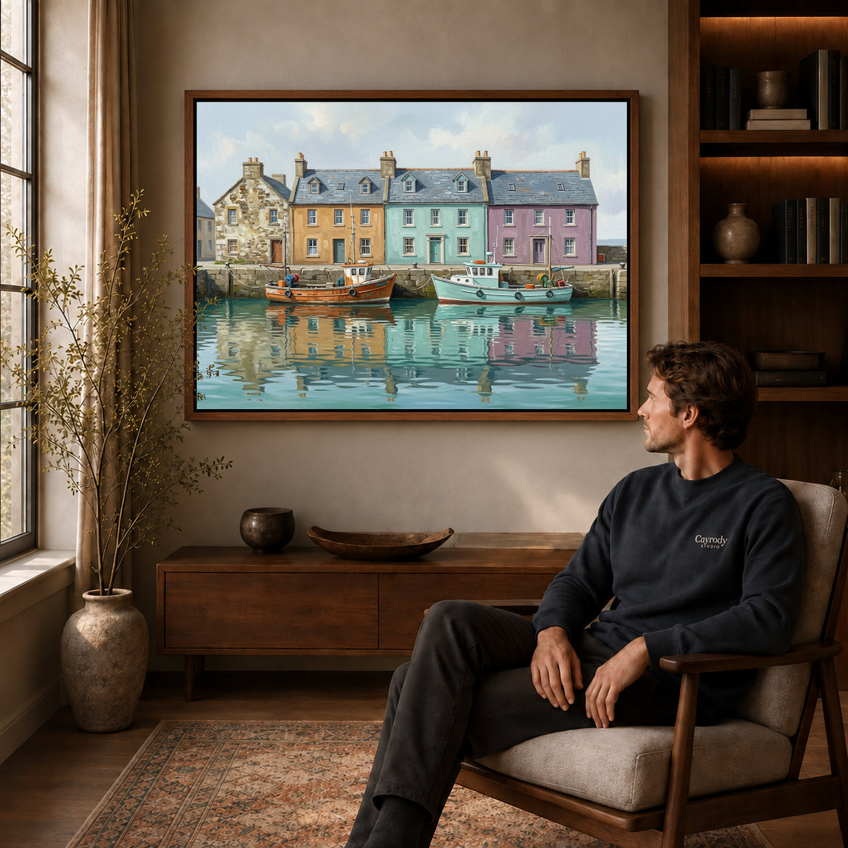 quiet harbor boats canvas art in a walnut frame above a console beside a seated man.