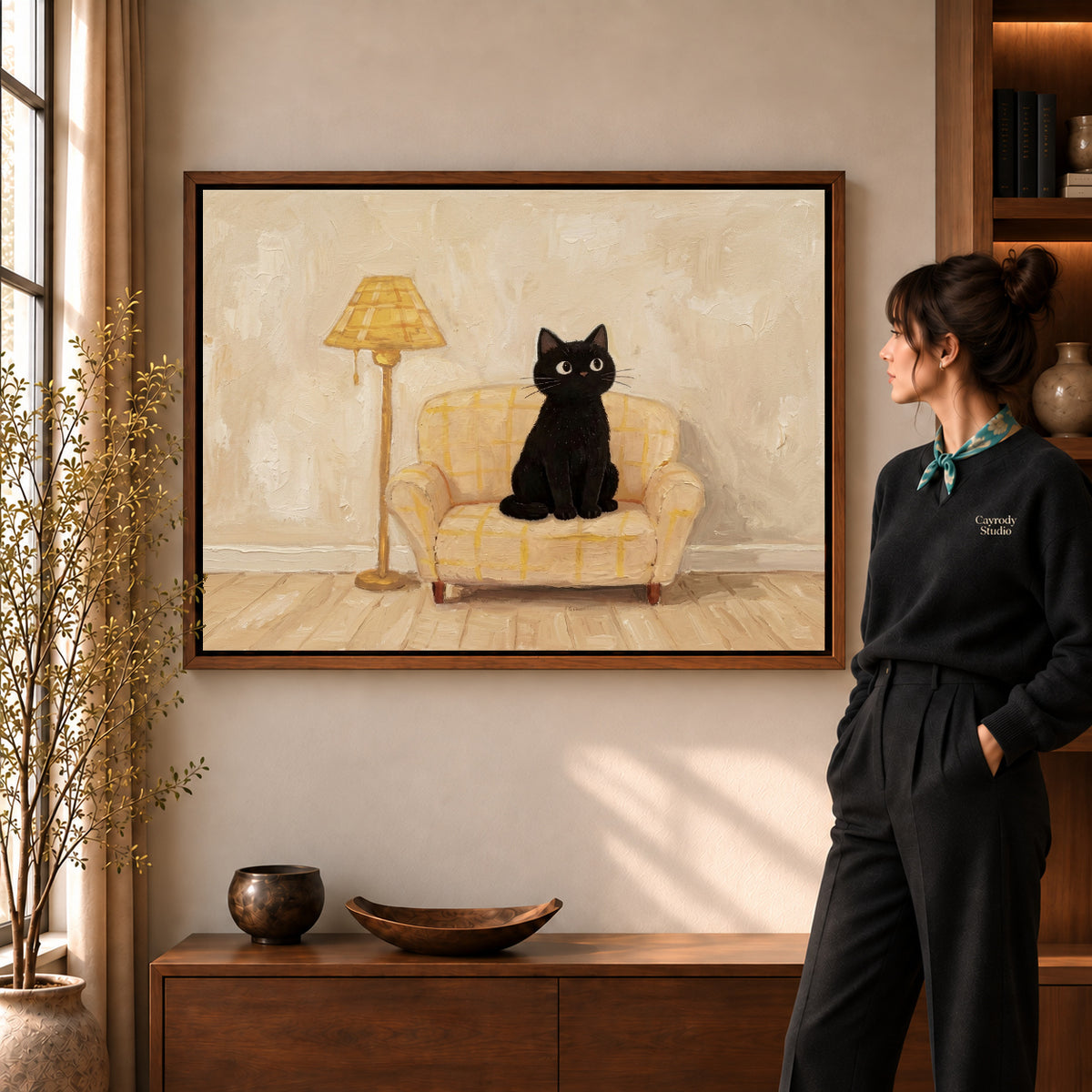 cozy armchair cat canvas art in a walnut frame beside a standing woman and wooden console.