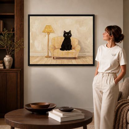 cozy armchair cat canvas art shown in the black frame option against a softly lit wall.