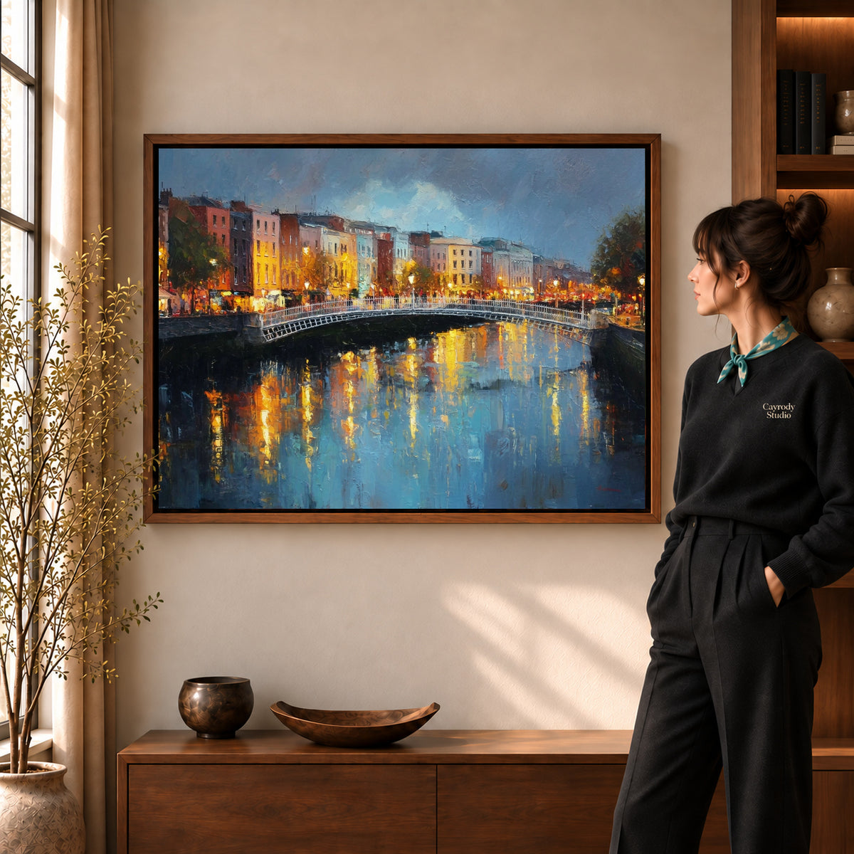 city bridge reflections canvas art in a walnut frame beside a standing woman and wooden console.